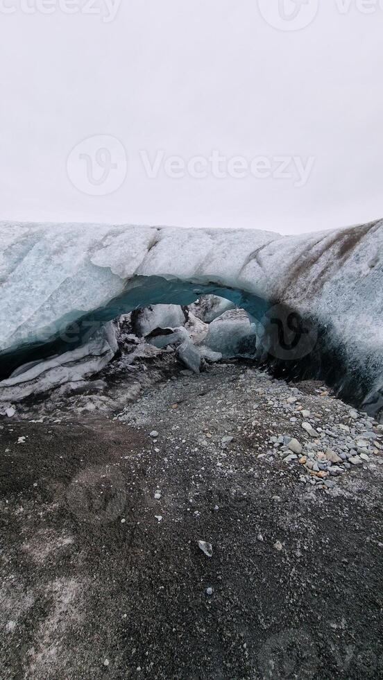 Vatnajokull glacier hiking inside caves, icelandic ice cap forming magical icebergs with blue transparent chunks. Wintry frozen glaciers with covered frost structure, climate change. photo