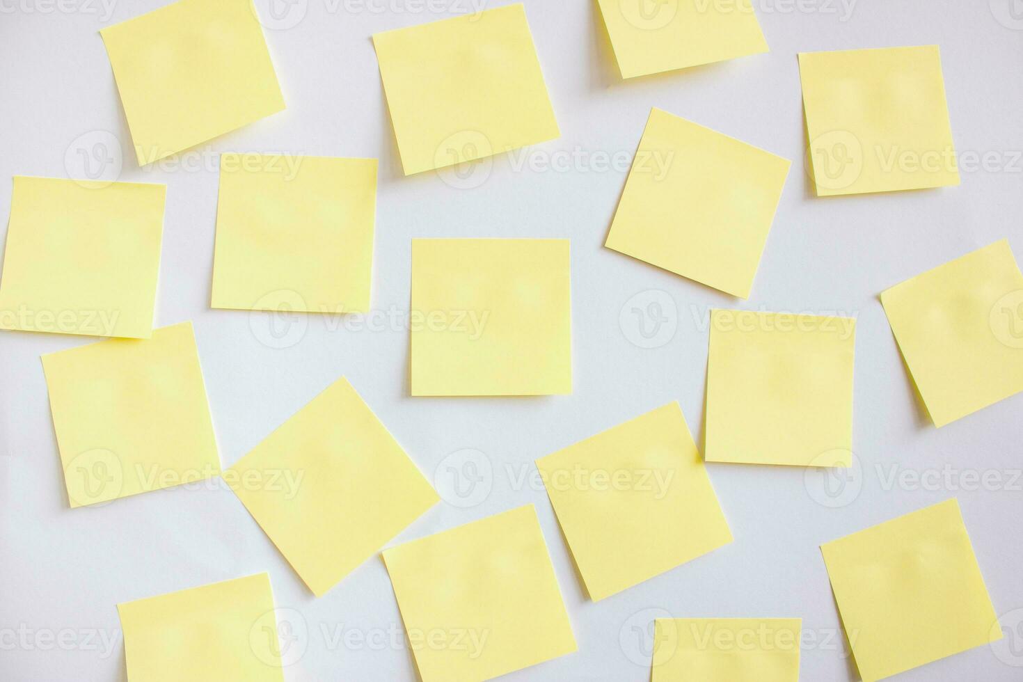 muchos amarillo documentos para notas en un blanco pared. foto