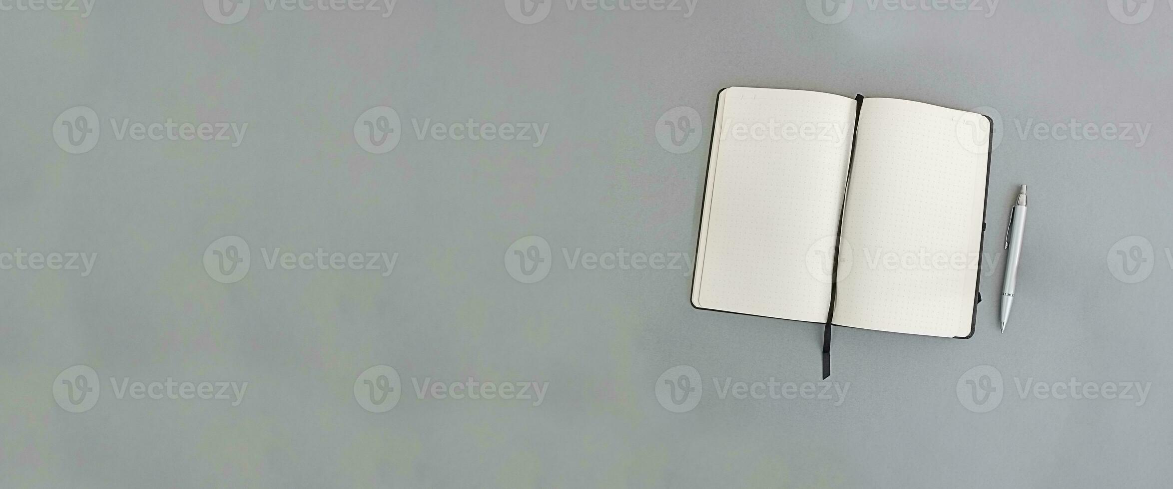 Notebook and pen on a gray background, copy space. Banner photo