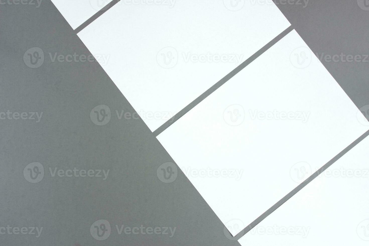 Empty white rectangle poster mockups lying diagonally on a dark gray background photo