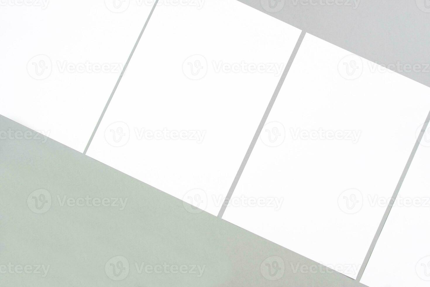 Empty white rectangle poster mockups lying diagonally on a gray background photo