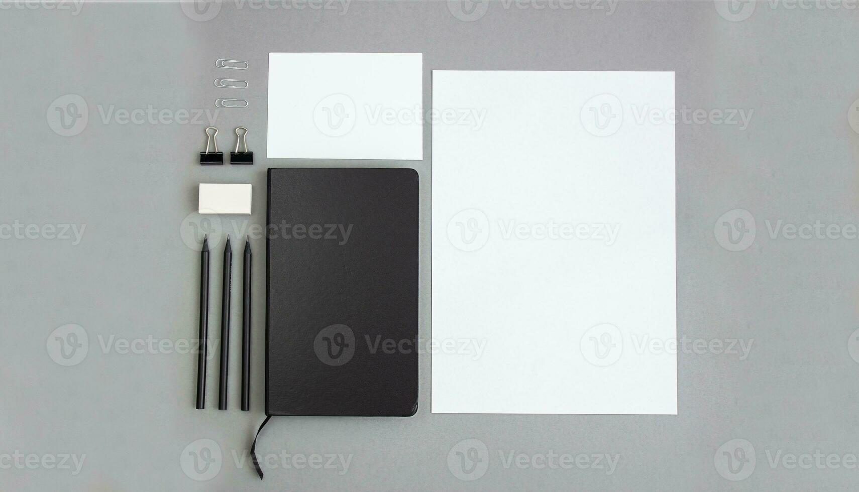 Notebook and stationery on a gray background, mockup. Flat lay. photo