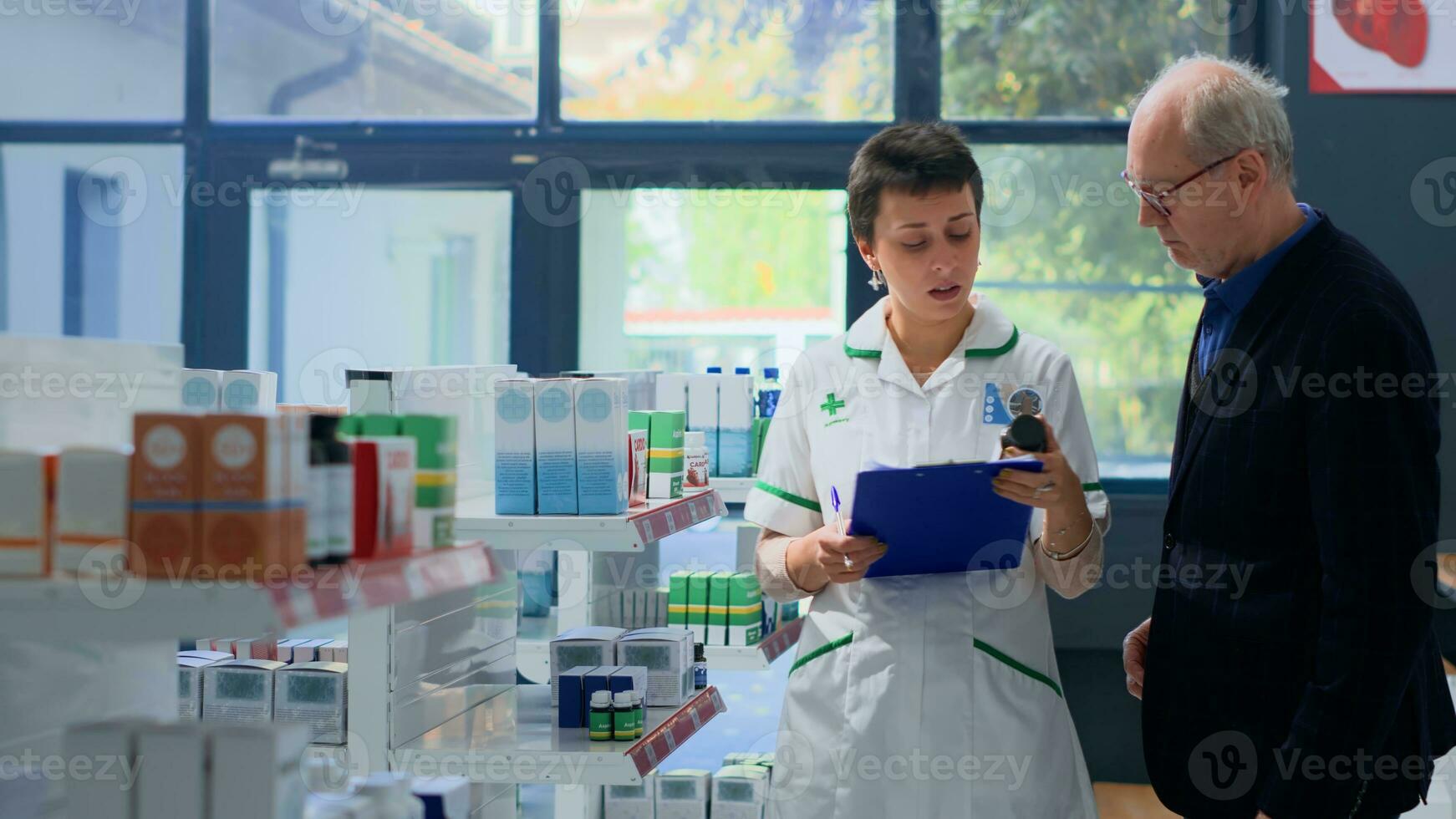 Elderly man in need of prescription drugs informations in apothecary, asking chemist checking medicinal products inventory. Pharmacy technician helping senior client with advice photo