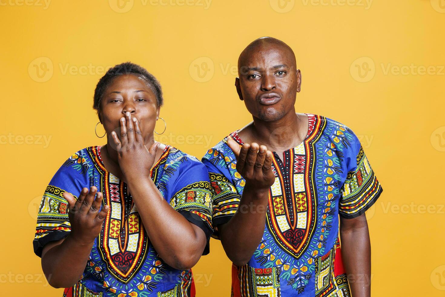 African american man and woman couple sending air kiss together, sharing love and looking at camera. Romantic boyfriend and girlfriend pair showing affection studio portrait photo