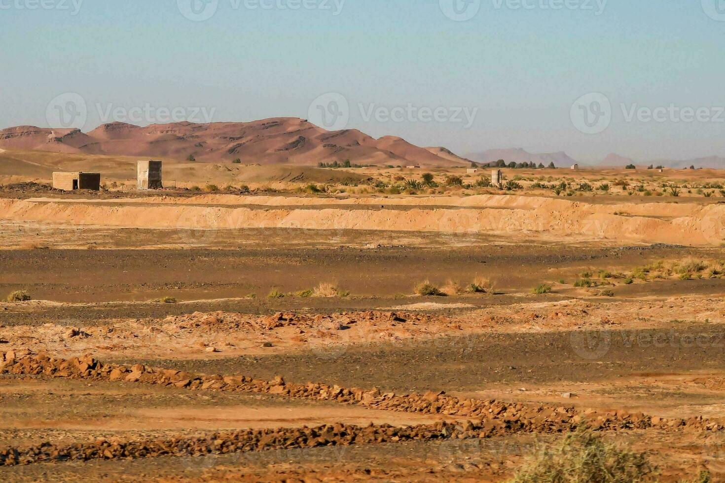 the desert is empty and barren with a few buildings photo