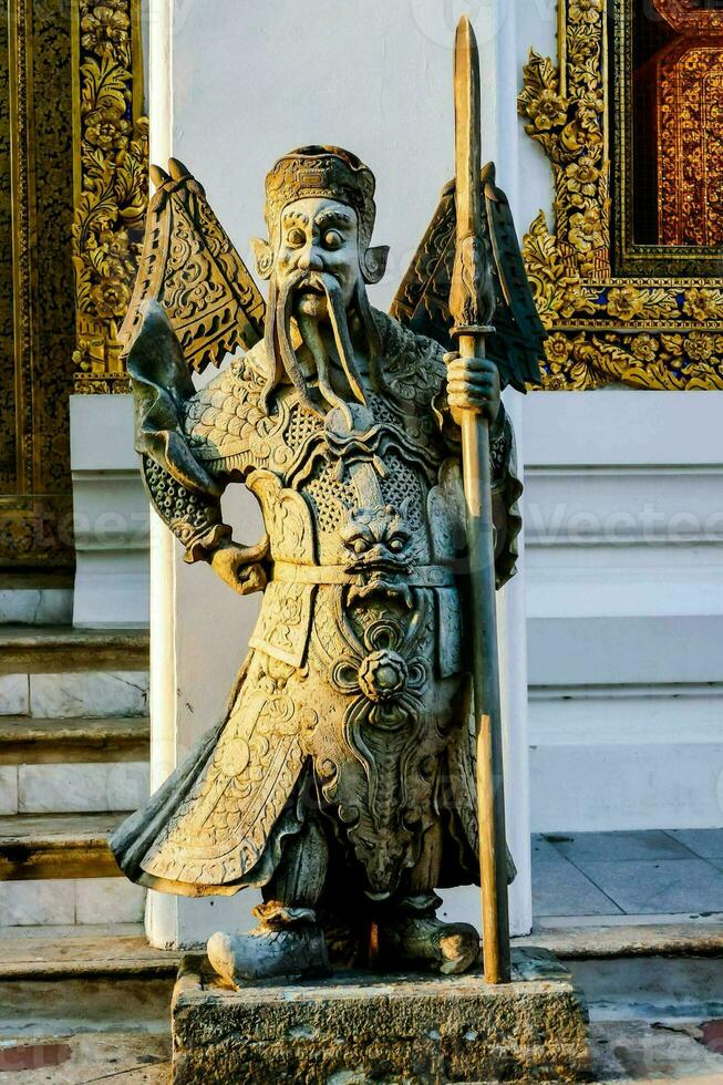 a statue of an asian man holding a sword photo