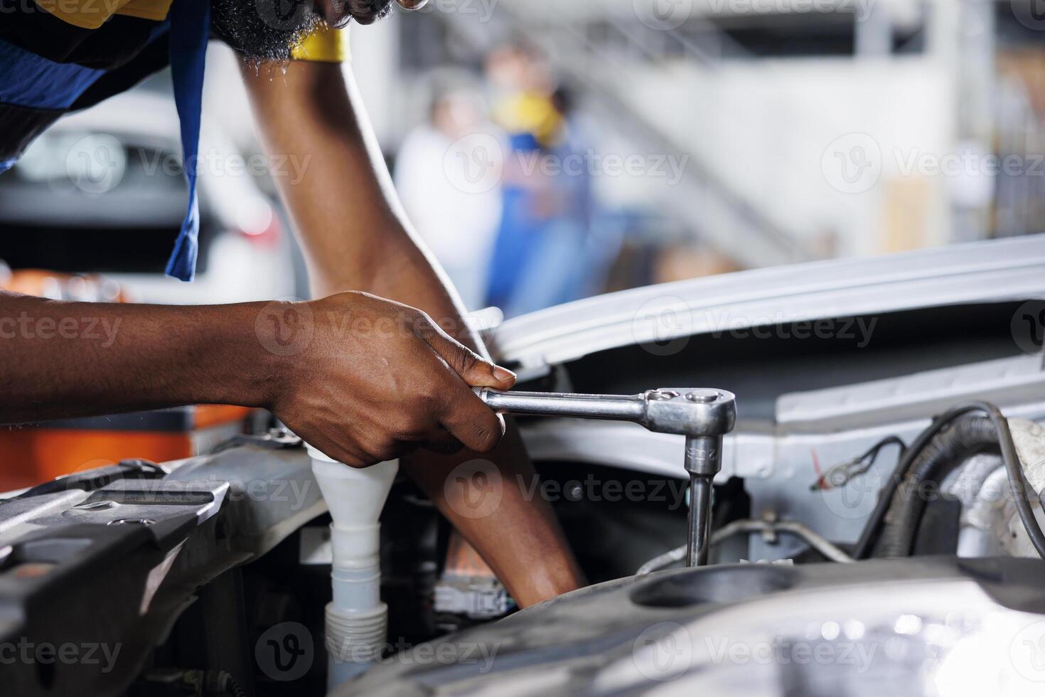 Serviceman in car service using professional mechanical tool to repair broken engine. Seasoned worker in garage repairs client automobile, ensuring optimal automotive performance, close up photo