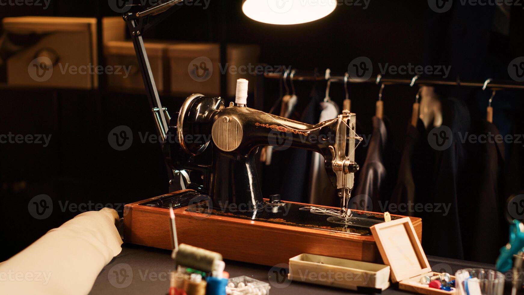Old school sewing machine in atelier, fashion industry with tailoring tools used to create custom made clothing line. Textile industry with professional instruments and workstations. Close up. photo