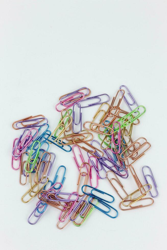 Colorful paperclips on white background, close-up shot. photo