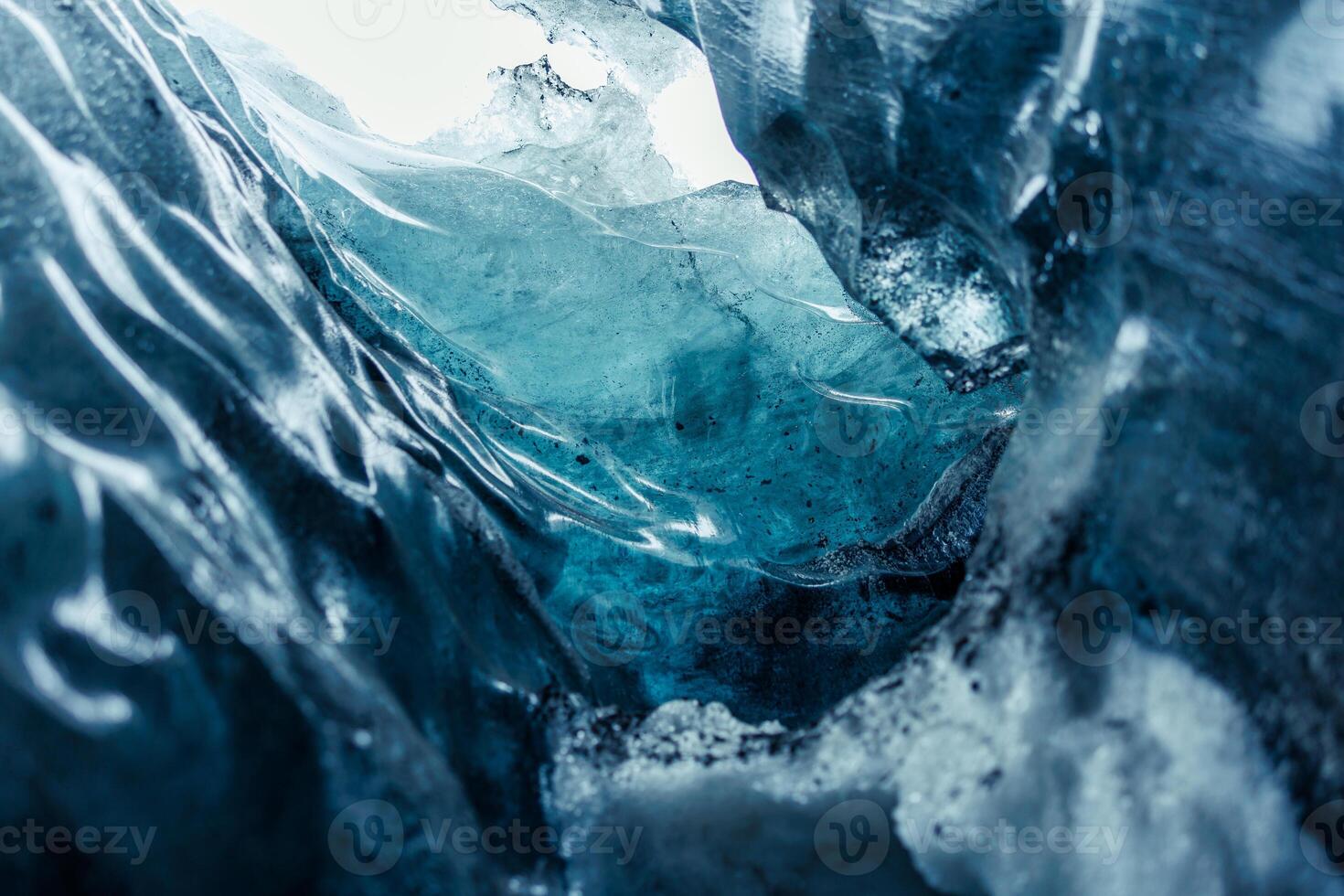 Frozen ice cap in vatnajokull caves melting due to global warming, frosty icelandic rocks forming massive crevasse and glacier hiking tunnels. Transparent glacial texture on cracked ice blocks. photo