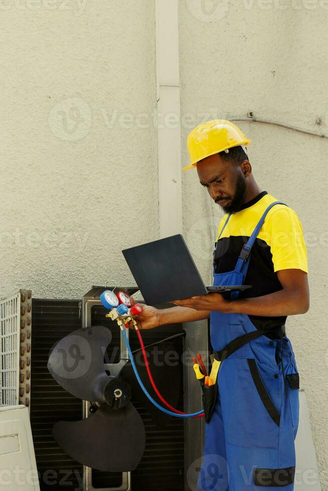 Efficient technician employed after complaints about ice on air conditioner internal parts. Seasoned mechanic using professional benchmarking tool to detect potential problems photo