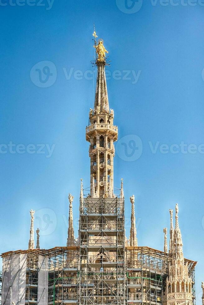 Golden Madonna statue on top of Milan Cathedral, Italy photo