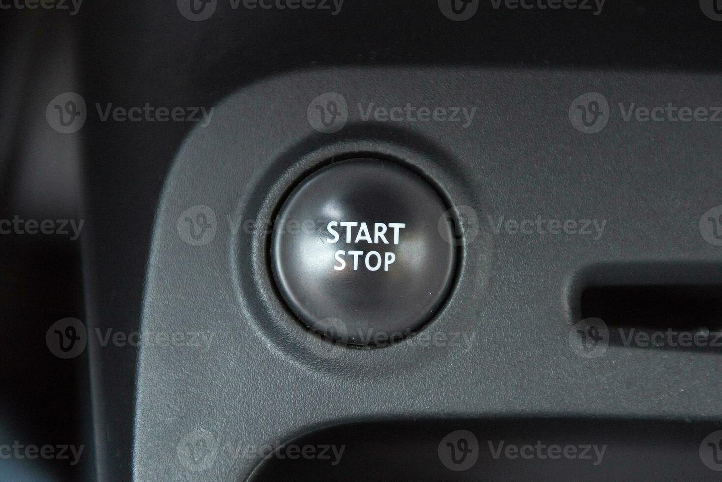 Car interior with closeup of engine start stop system button photo