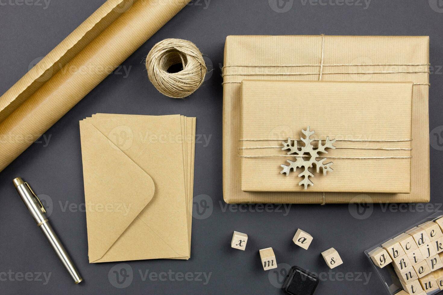 Christmas envelope mockup with handmade gift boxes and decoration on dark background. Festive styled composition. Top view. Copy space. photo