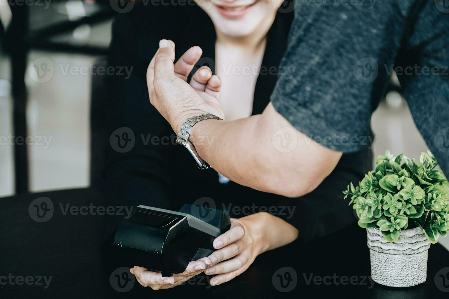 Payment security technology concept and service fees, Employees are holding electronic card machines for customers to use smartwatches to pay via paywave technology. photo
