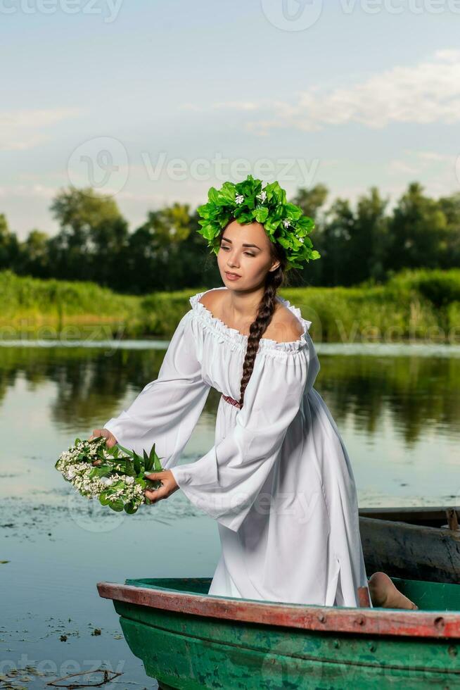 joven sexy mujer en barco a puesta de sol. el niña tiene un flor guirnalda en su cabeza, relajante y navegación en río. fantasía Arte fotografía. foto