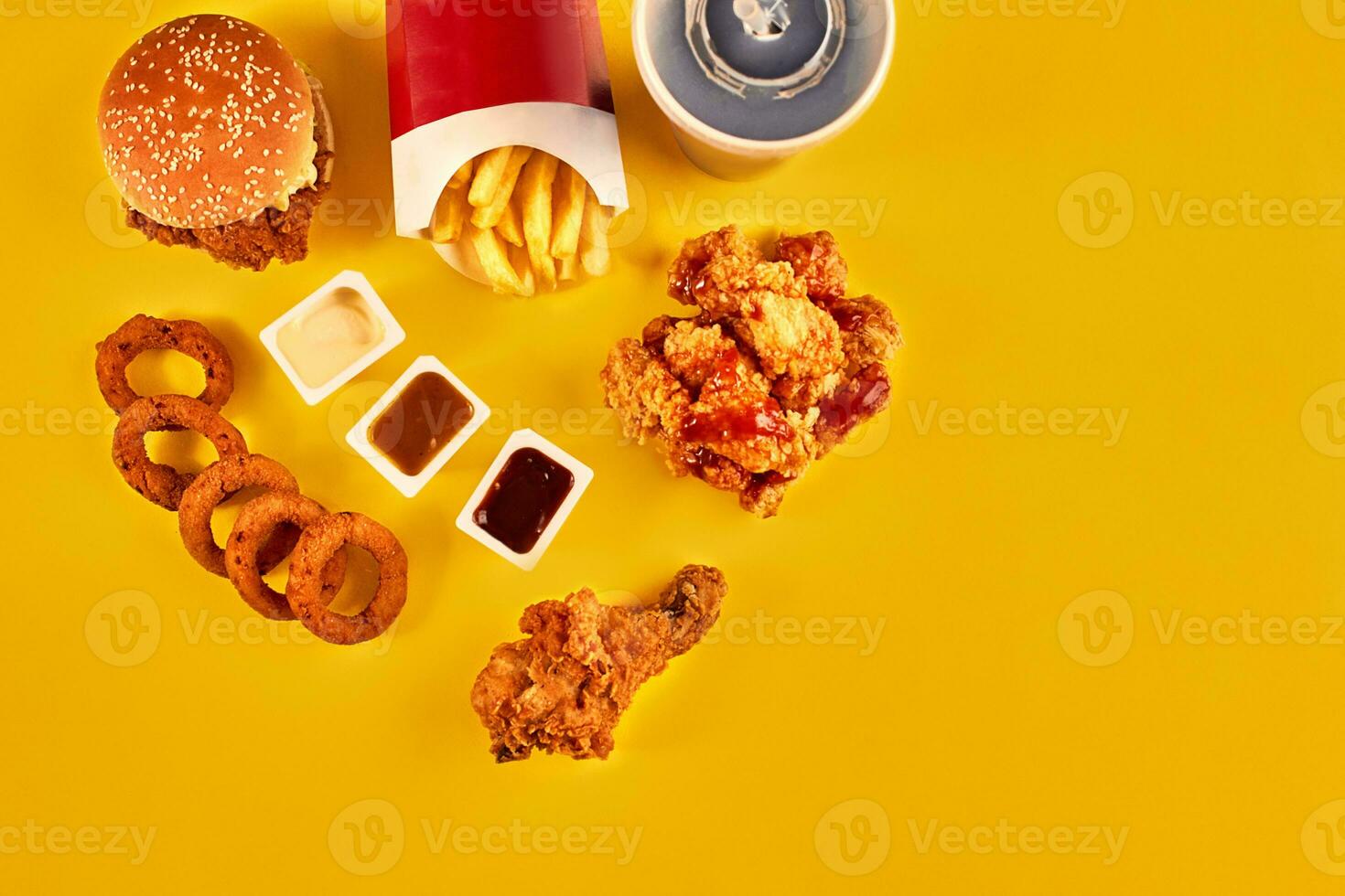 Top view hamburger, french fries and fried chicken on yellow background. Copy space for your text. photo