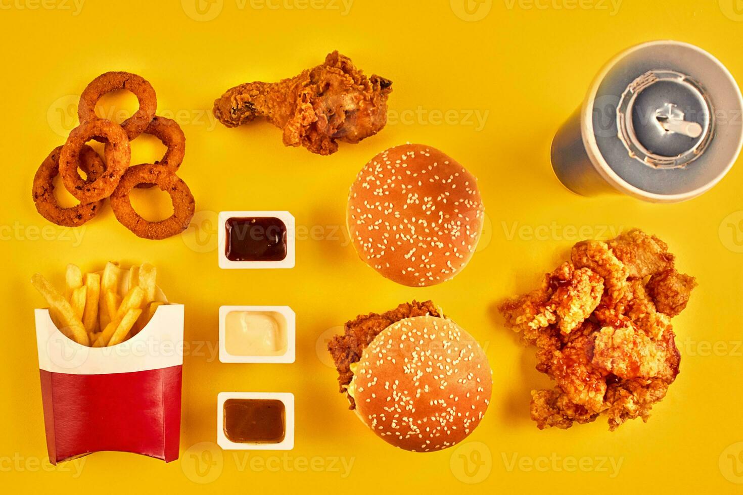 Top view hamburger, french fries and fried chicken on yellow background. Copy space for your text. photo