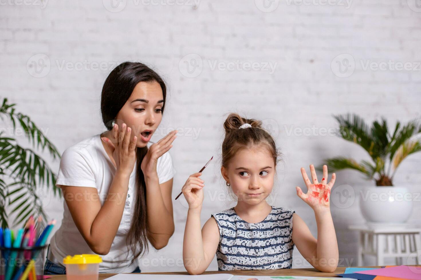 Happy family. Mother and daughter together paint. photo