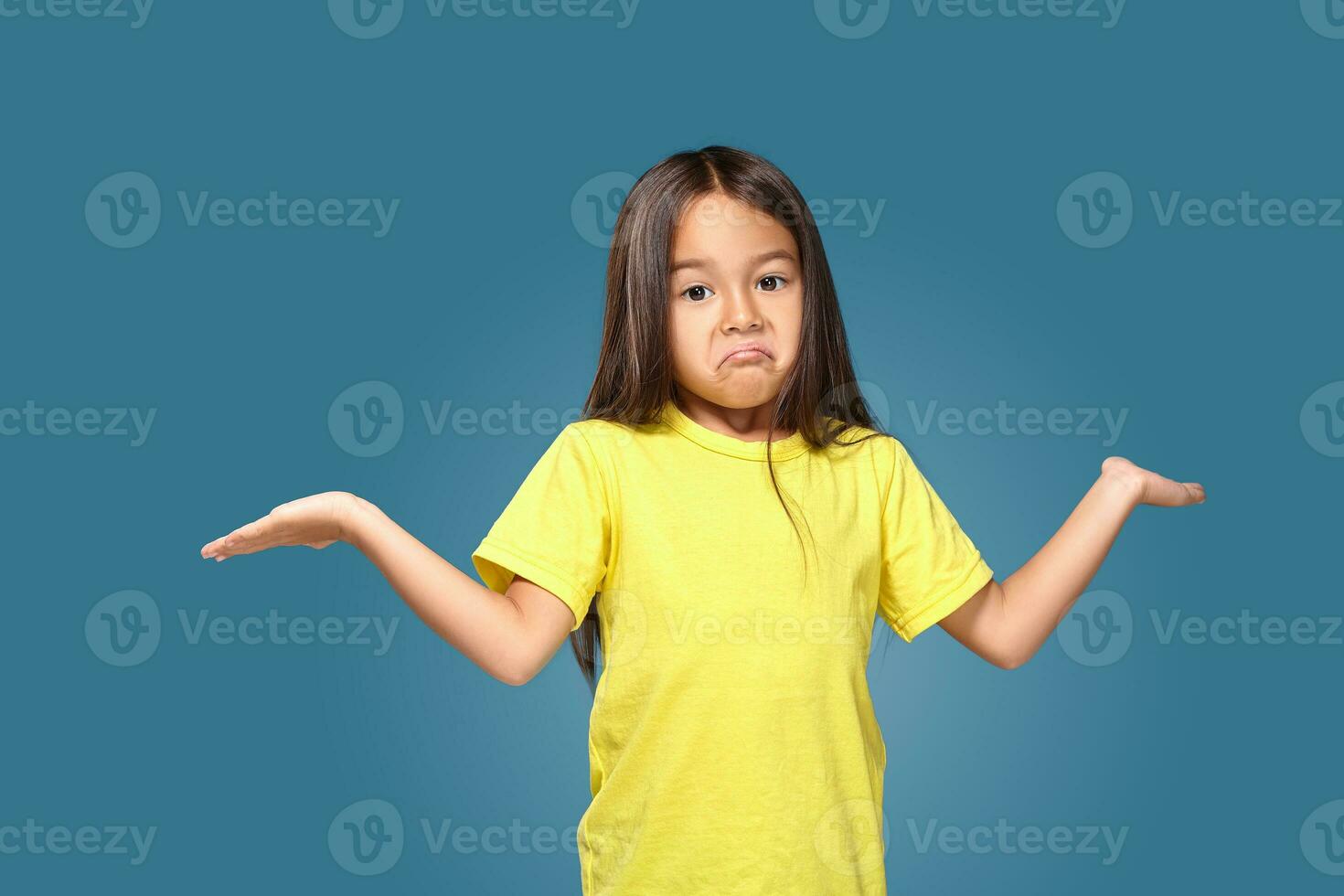 Surprised girl with spread arms on blue background photo