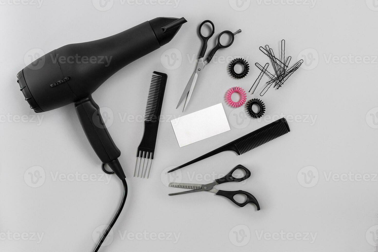 Hairdresser set with various accessories on gray background photo