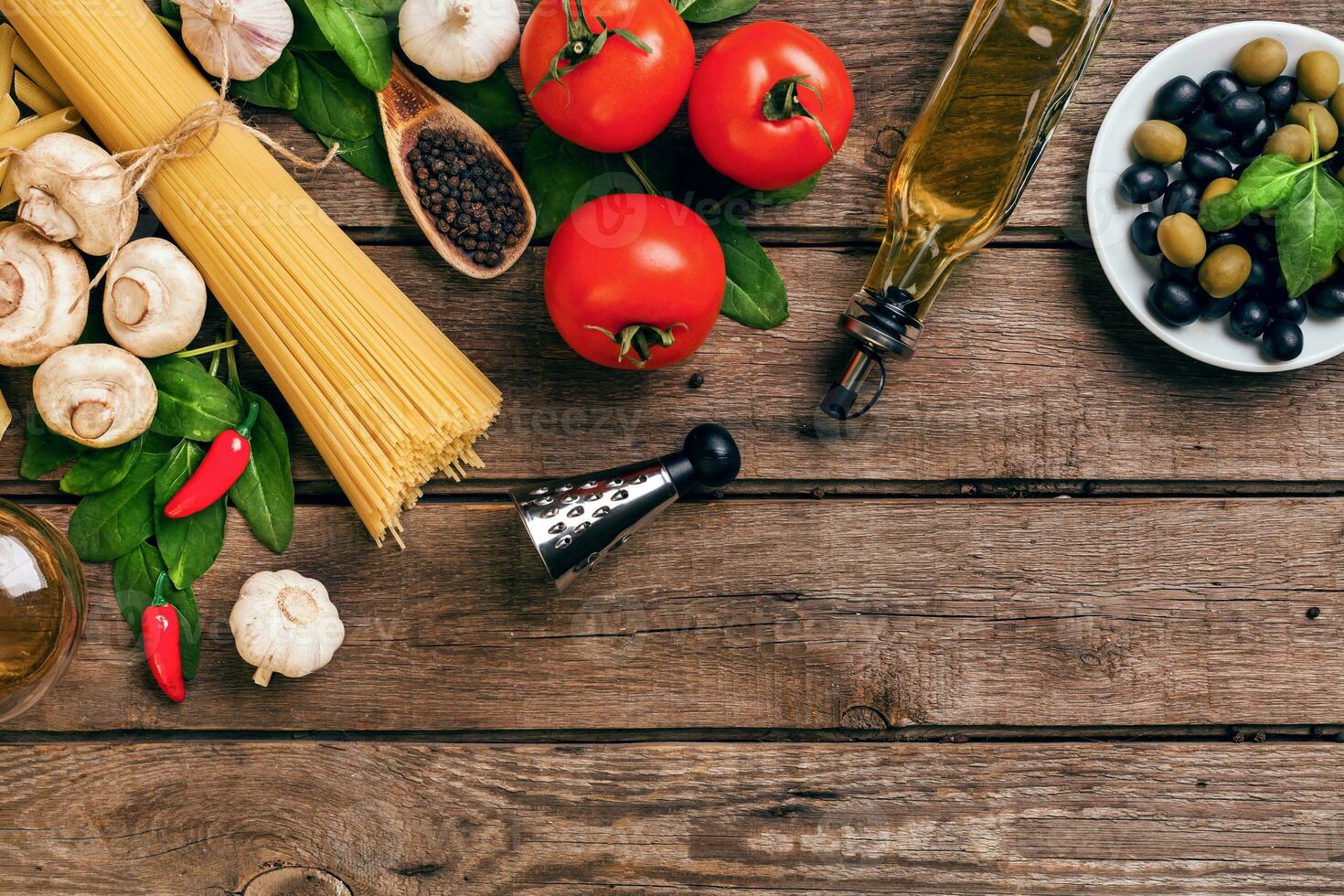 Pasta and ingredients on wooden background with copy space. Top view. Vegetarian food, healthy or cooking concept. photo