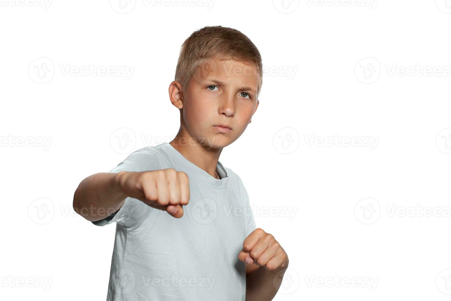 Close-up portrait of a blonde teenage boy in a white t-shirt posing isolated on white studio background. Concept of sincere emotions. photo