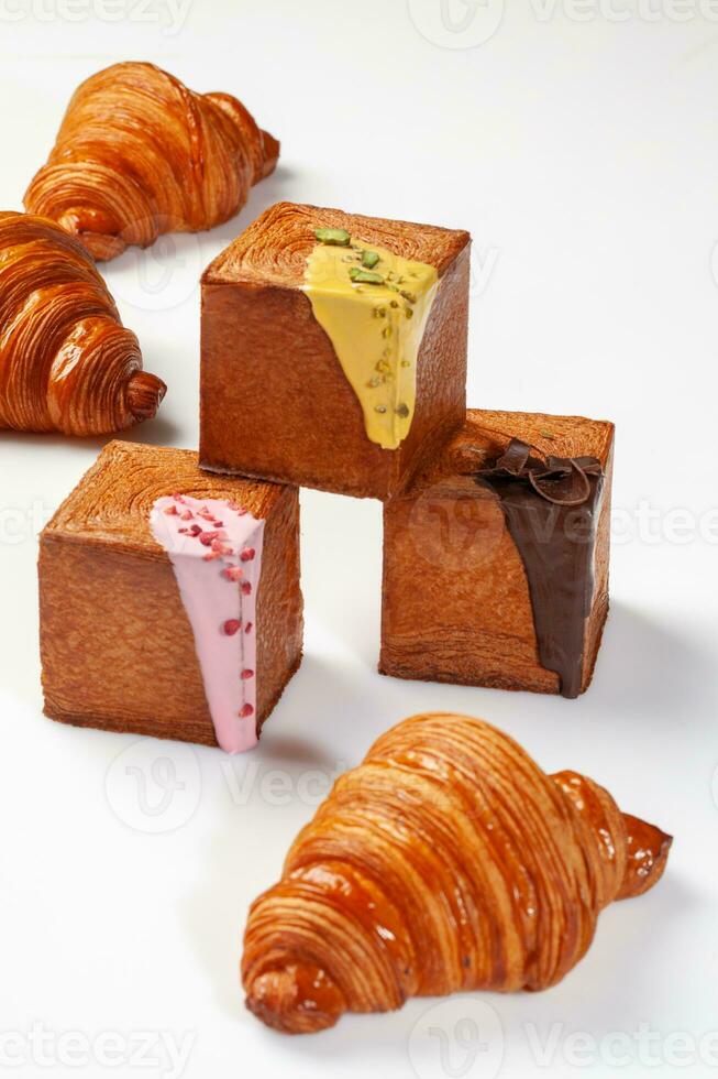 francés creciente y cubo conformado croissants con dulce salsas, chocolate copos, pistachos y baya desmoronarse foto