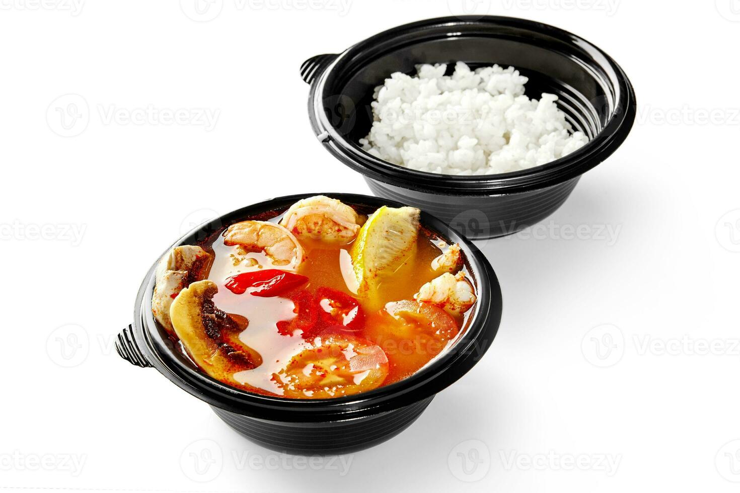 Thai soup tom yum with shrimps, mushrooms, chili peppers, tomatoes and lemon served with rice photo