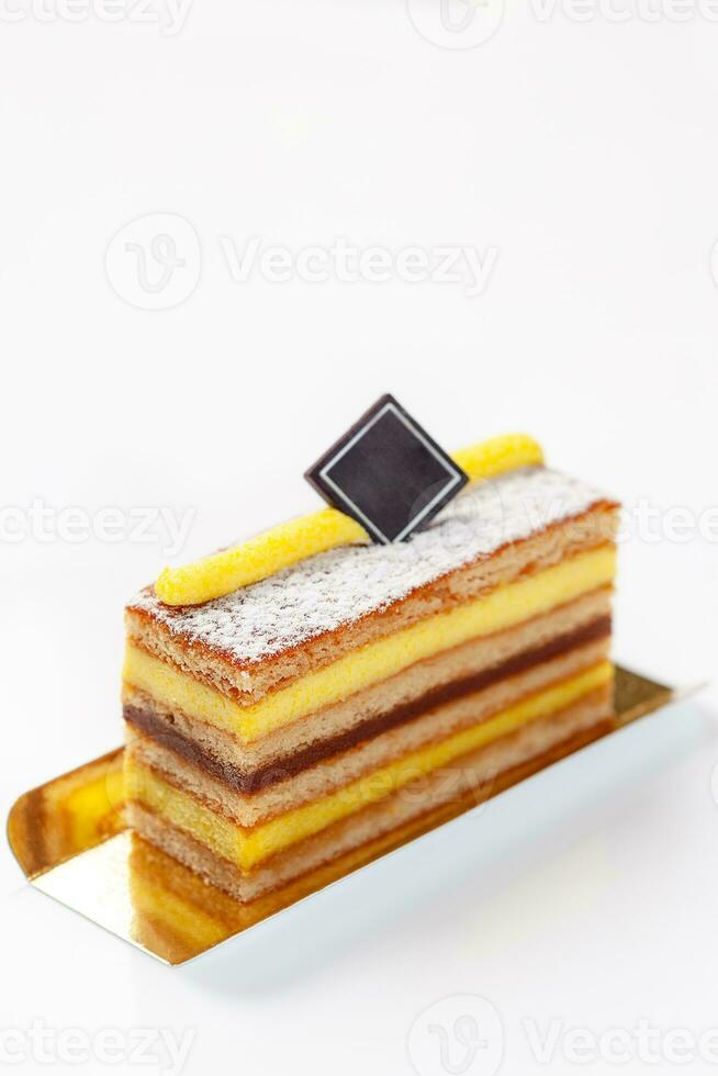 Honey cake slice with mascarpone and caramel cream, powdered sugar and piece of chocolate photo