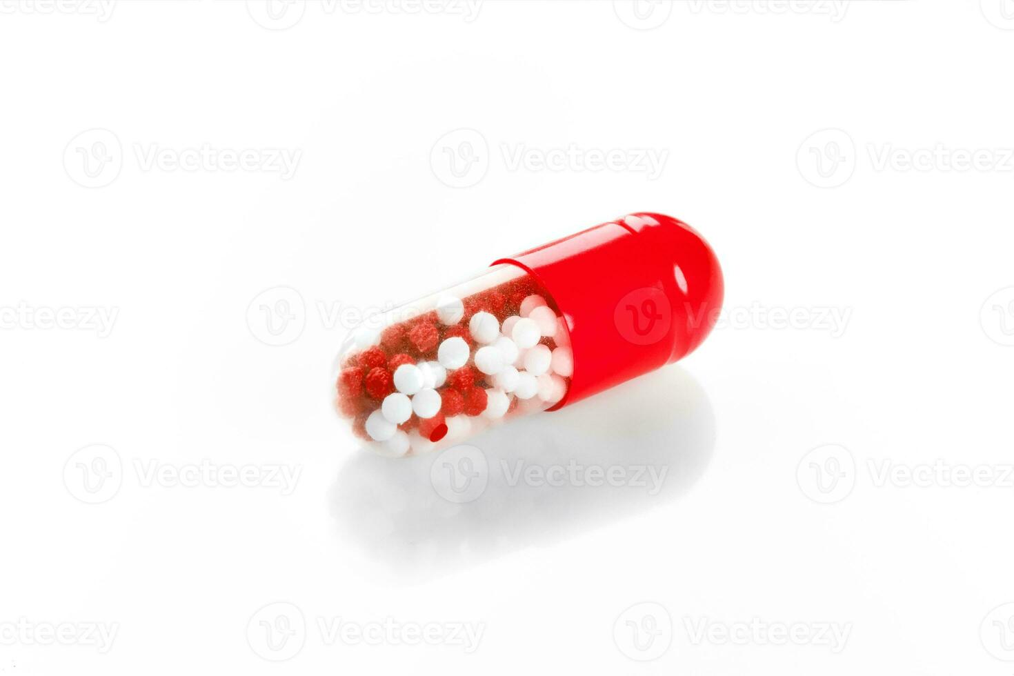 Macro red medical pill tablet with pellet, microgranules isolated on white photo