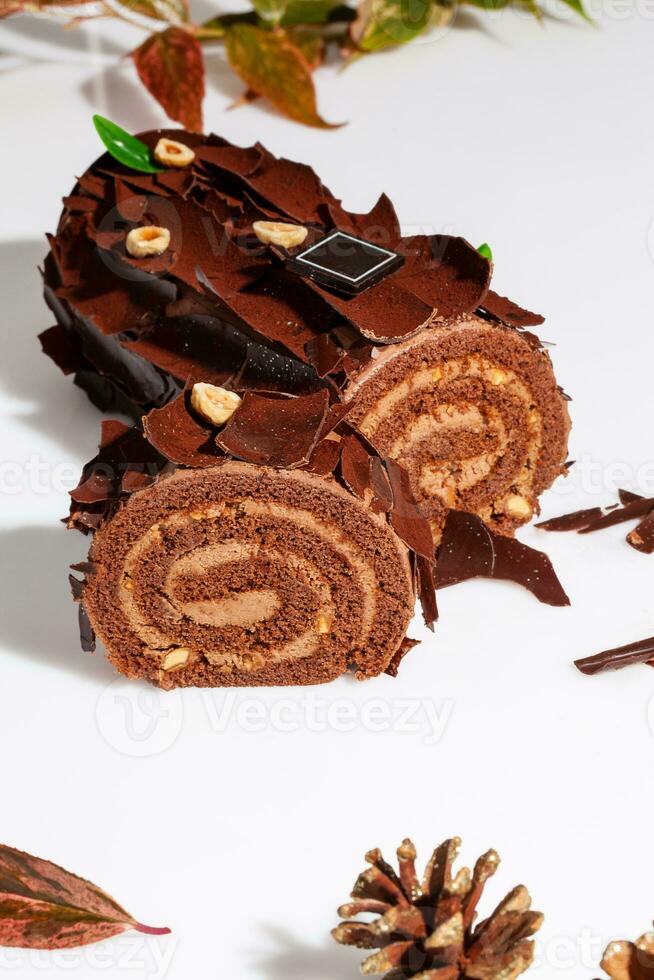 Sliced chocolate cake roll with buttercream and hazelnuts photo