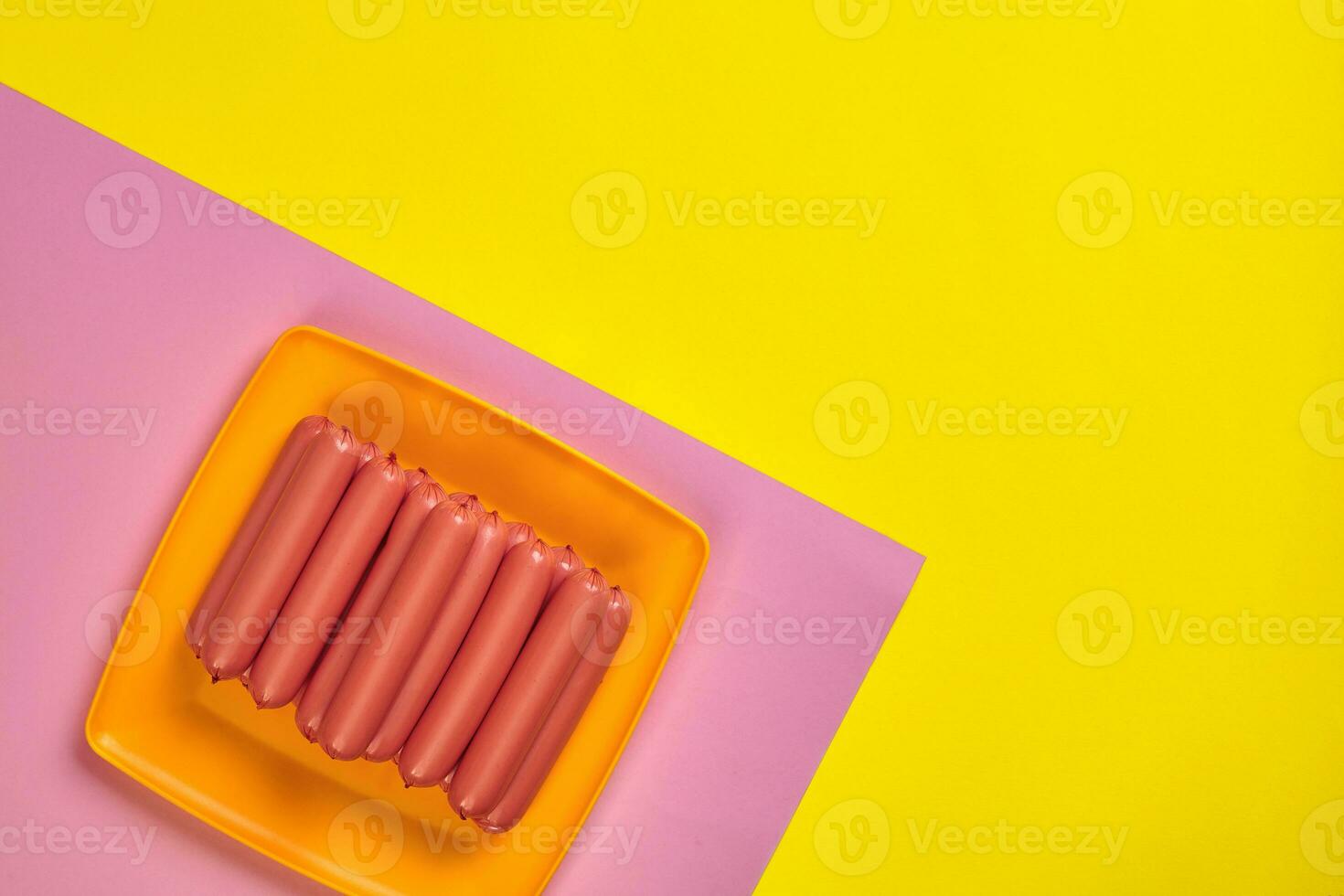Sausages on a yellow and pink minimal background. Flat lay. Top view. photo