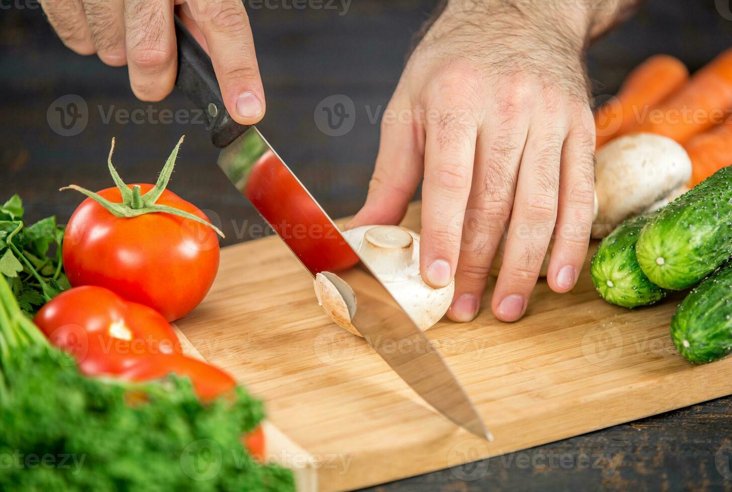 Male hands cutting vegetables for salad photo