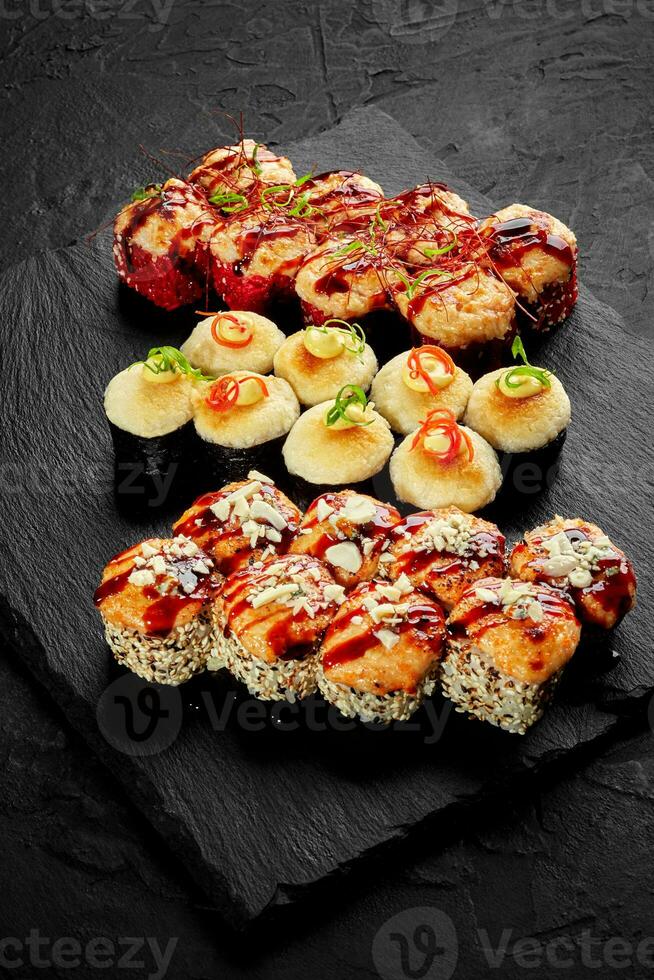 Set of baked rolls with melted cheese hats on black slate board photo