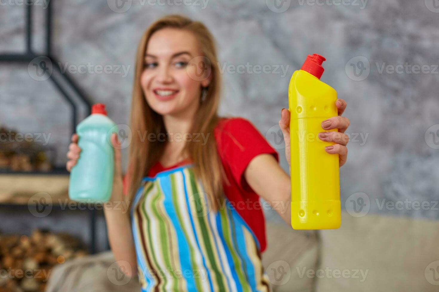 Woman compares two detergent bottle at home cleaning in living room. Home work. photo