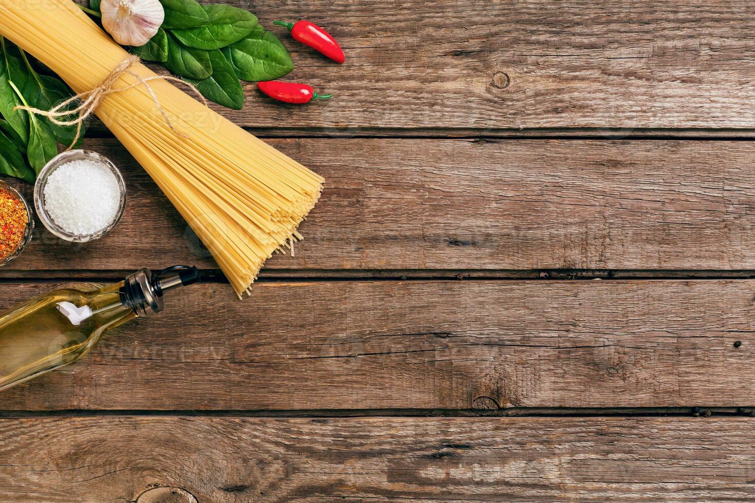 Pasta and ingredients on wooden background with copy space. Top view. Vegetarian food, healthy or cooking concept. photo