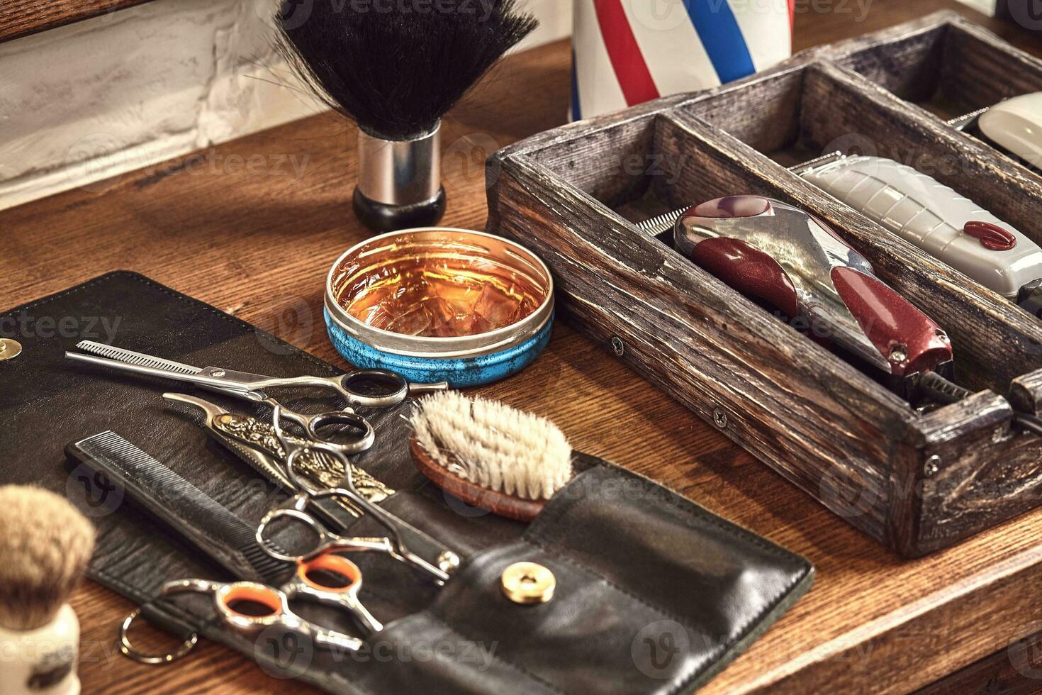 Hairdresser tools on wooden background. Top view on wooden table with scissors, comb, hairbrushes and hairclips, trimmer. photo