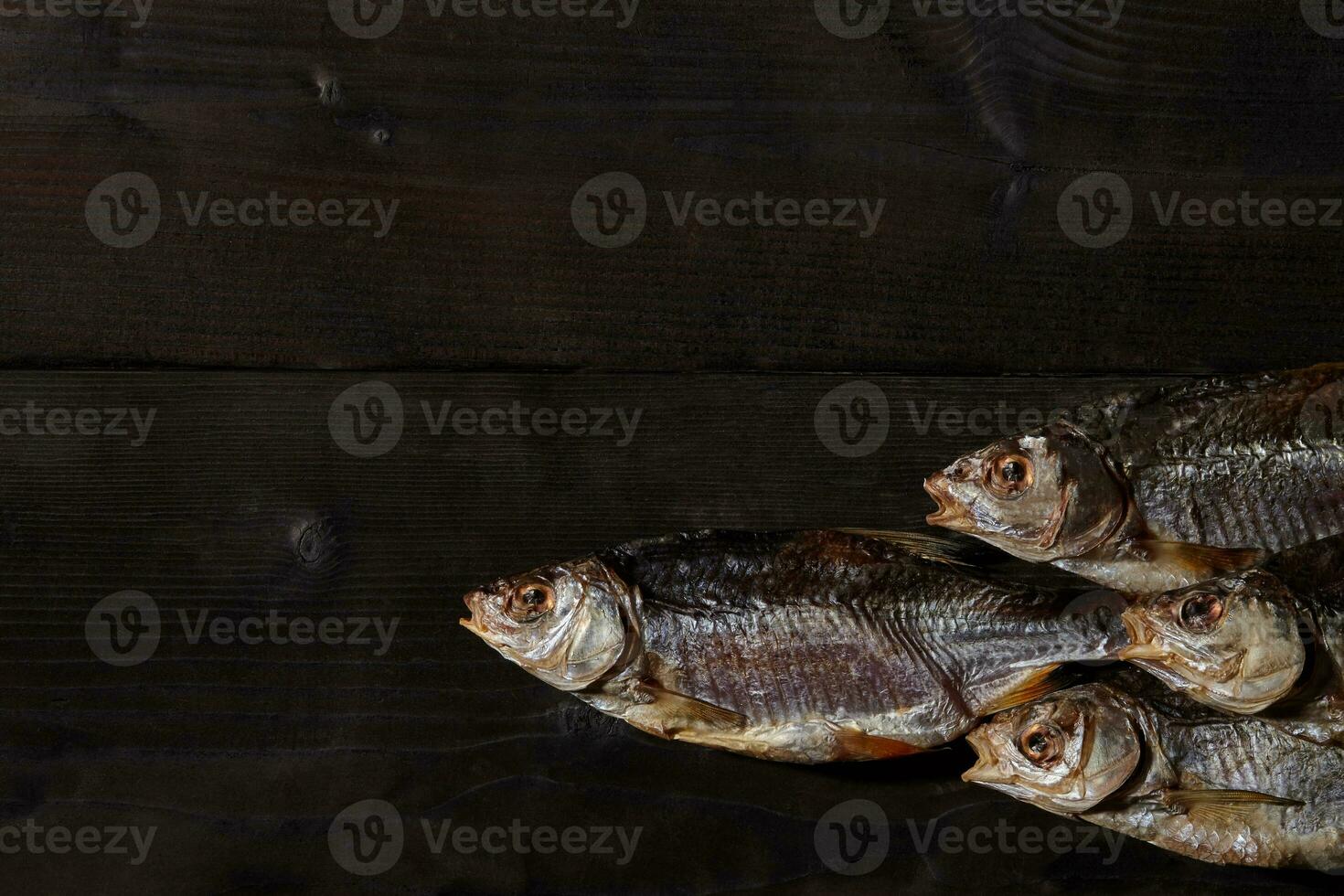 Jerky or dried salted roach, delicious clipfish on wooden background. Popular beer snack. Traditional way of preserving fish. Close up photo