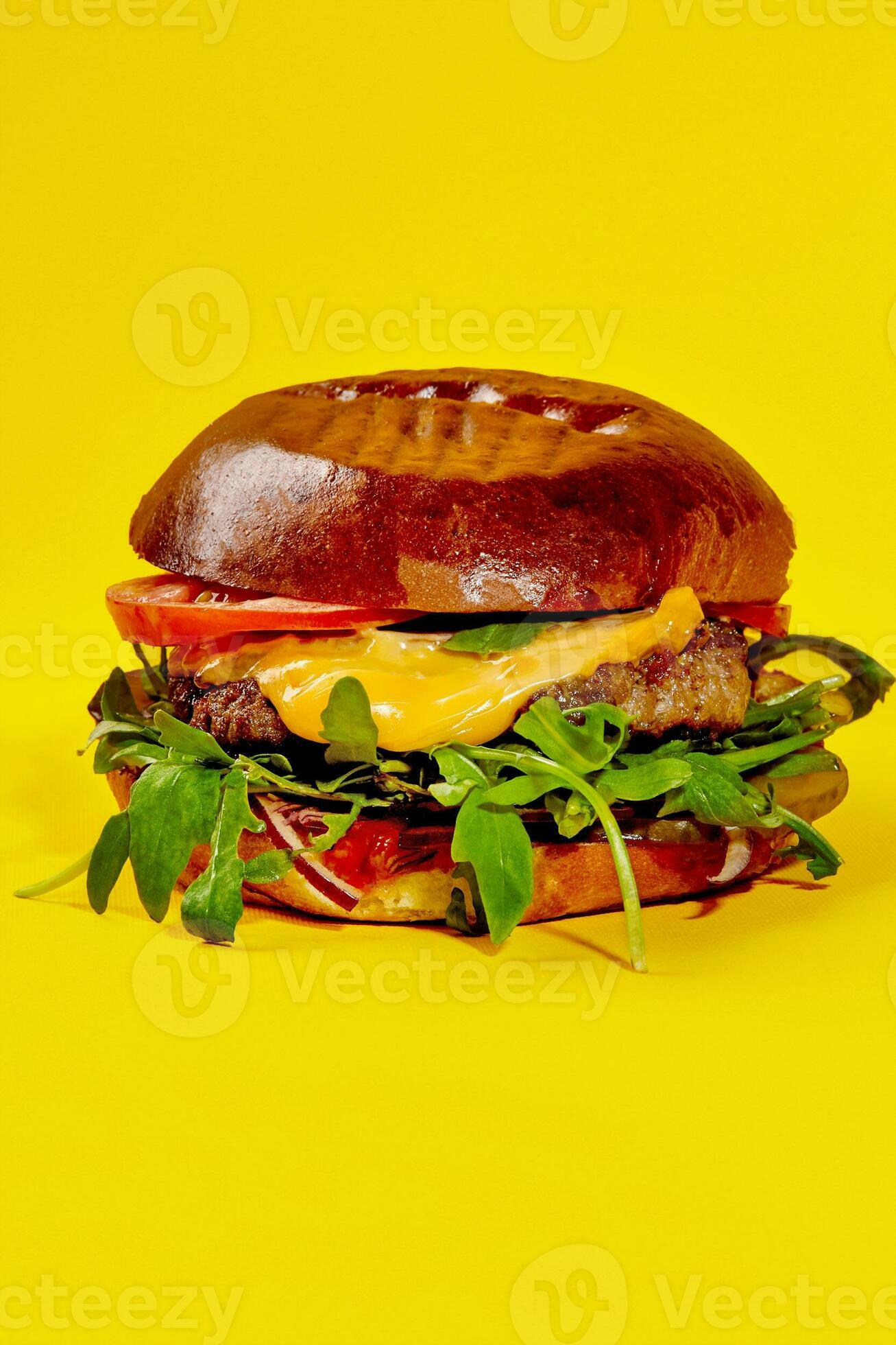 Hamburger with veal patty, cheese, tomatoes, onion and greens isolated