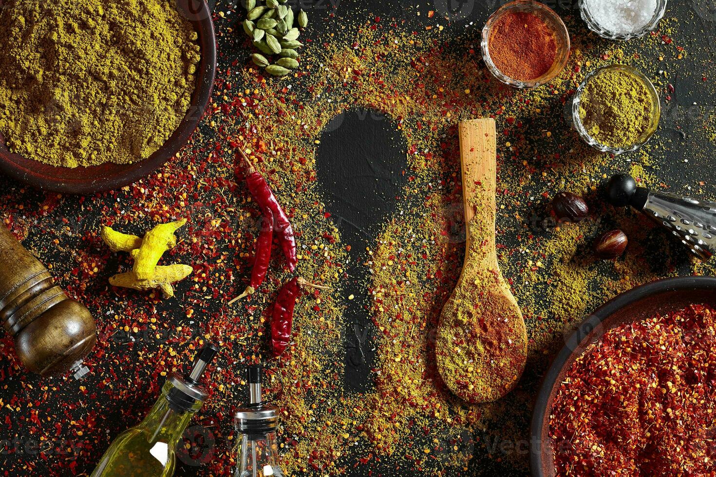 Assorted spices on dark black background. Seasonings for food. Curry, paprika, pepper, cardamom, turmeric. Top view. photo