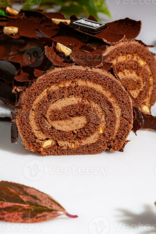 Sliced log-shaped chocolate roll with buttercream and hazelnuts photo