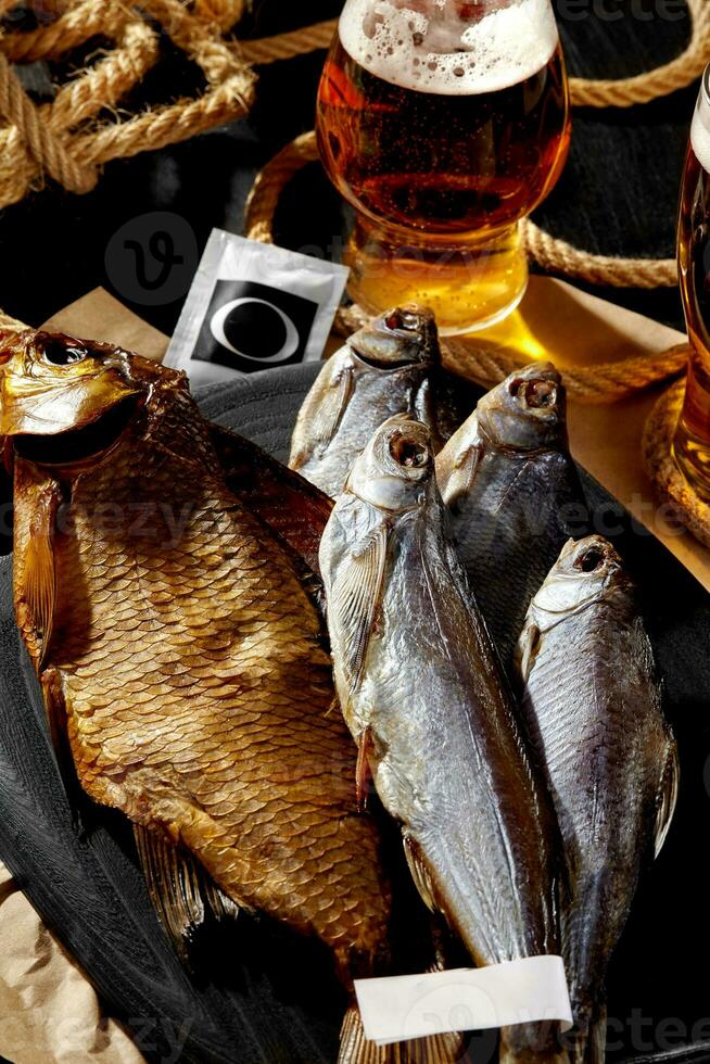 Various whole air-dried and smoked fish served with amber lager photo