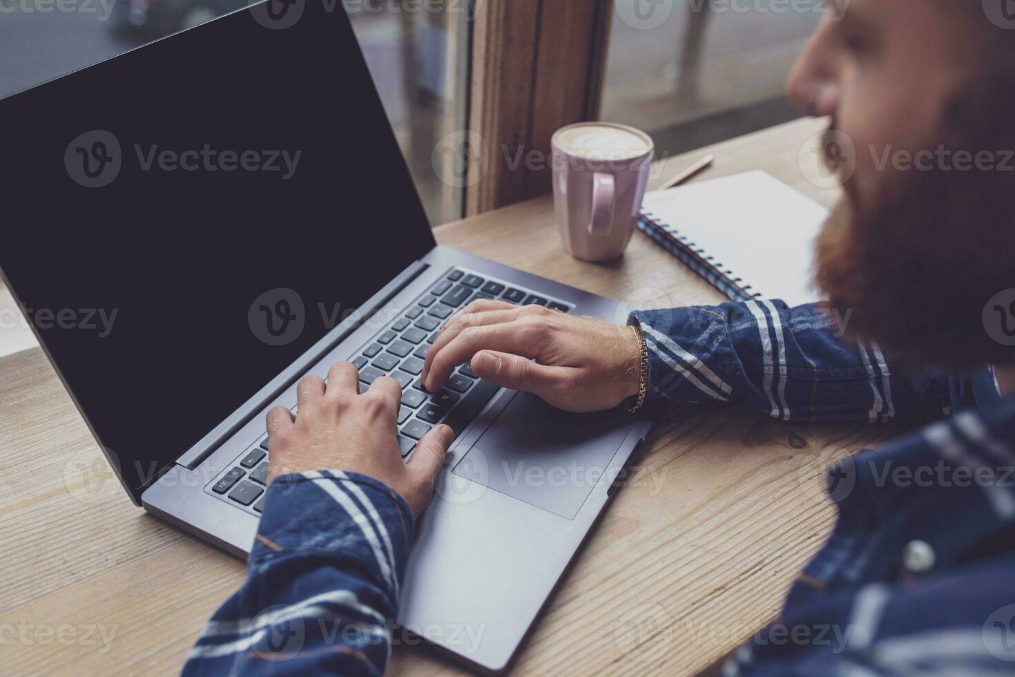 Cropped image of young man chatting via net-book during work bre photo