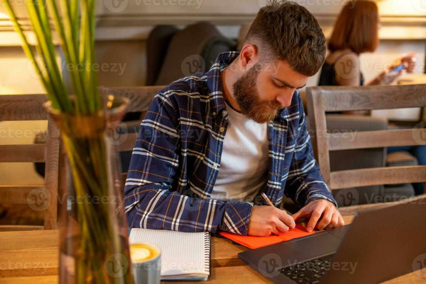 Casual business man or freelancer planning his work on notebook, working on laptop computer with smart phone, cup of coffee on table at coffee shop or home office. photo