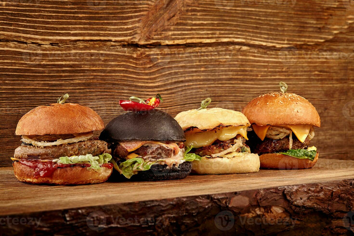 Set of burgers with meat, cheese, tomatoes, mayonnaise on wooden table and background. Space for text. photo