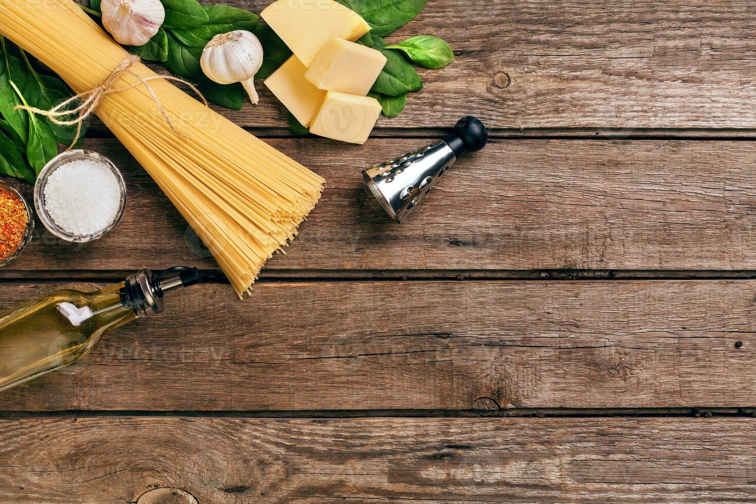 Pasta and ingredients on wooden background with copy space. Top view. Vegetarian food, healthy or cooking concept. photo