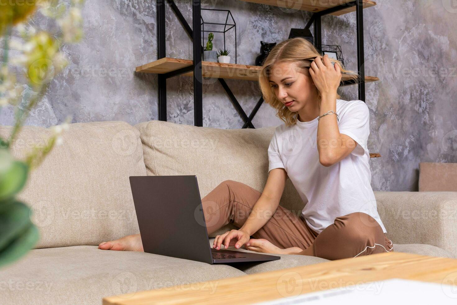Young beautiful woman using laptop computer smiling happy watching and browsing or doing online internet shopping at home. photo