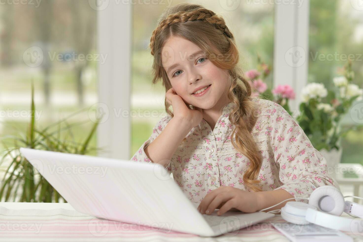 Cute and happy little girl children using laptop computer photo