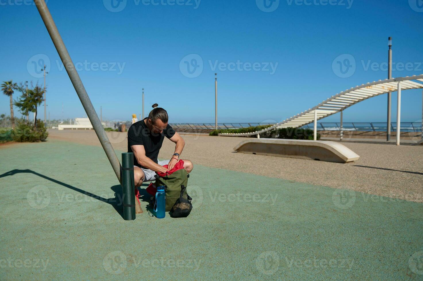 Caucasian handsome muscular sportsman ready for a bodyweight training outdoors, in urban sports ground on sunny day photo